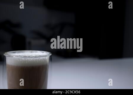 tasse Kaffee in einem Doppel-Botoom Glas auf weißem Tisch in der grauen Küche. Hochwertige Fotos Stockfoto