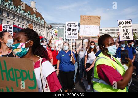 Mitarbeiter des National Health Service (NHS), die Masken tragen, protestieren gegen ihren Ausschluss von einer kürzlich angekündigten Lohnerhöhung im öffentlichen Sektor vor dem St. Thomas' Hospital in London.rund 900,000 Beschäftigte des öffentlichen Sektors in ganz Großbritannien werden in diesem Jahr als Dankesgeste des Finanzministeriums eine überhöhte Lohnerhöhung erhalten Bemühungen während der Coronavirus-Pandemie. Die Gehaltserhöhung ist jedoch ausschließlich für Krankenschwestern und andere Mitarbeiter vor der Haustür aufgrund eines dreijährigen Lohnverhandlungs, den sie 2018 ausgehandelt haben, was sie dazu führte, aus Protest auf die Parliament Street in Richtung Downing Street in London zu marschieren. Stockfoto