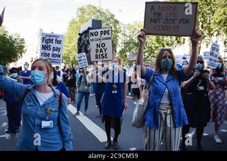 Mitarbeiter des National Health Service (NHS) werden maskiert gesehen und zeigen Plakate in ihrem Protest gegen den Ausschluss von einer kürzlich angekündigten Lohnerhöhung im öffentlichen Sektor auf dem parliament Square.rund 900,000 Beschäftigte des öffentlichen Sektors in ganz Großbritannien werden in diesem Jahr als Dankesgeste des Finanzministeriums eine überhöhte Lohnerhöhung erhalten Für ihre Bemühungen während der Coronavirus-Pandemie. Die Gehaltserhöhung ist jedoch ausschließlich für Krankenschwestern und andere Mitarbeiter vor der Haustür aufgrund eines dreijährigen Lohnverhandlungs, den sie 2018 ausgehandelt haben, was sie dazu führte, aus Protest auf die Parliament Street zu marschieren, die zur Downing Street in Lond führt Stockfoto