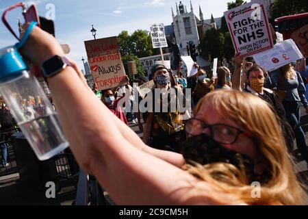 Mitarbeiter des National Health Service (NHS), die Masken tragen, sind mit Plakaten zu sehen, die gegen ihren Ausschluss von einer kürzlich angekündigten Lohnerhöhung im öffentlichen Sektor auf dem parliament Square protestieren.rund 900,000 Beschäftigte des öffentlichen Sektors in ganz Großbritannien werden in diesem Jahr als Dankesgeste des Finanzministeriums eine überhöhte Lohnerhöhung erhalten Während der Coronavirus-Pandemie. Die Gehaltserhöhung ist jedoch ausschließlich für Krankenschwestern und andere Mitarbeiter vor der Haustür aufgrund eines dreijährigen Lohnverhandlungs, den sie 2018 ausgehandelt haben, was sie dazu führte, aus Protest auf die Parliament Street in Richtung Downing Street in London zu marschieren. Stockfoto