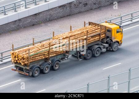 Ein Holztruck fährt entlang der Stadtautobahn beladen mit Sägeschnitt Baumstämmen Stockfoto