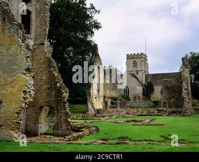 Ruinen von Minster Lovell Hall und St Kenelm's Church, Witney, Oxfordshire. Blick am südwestlichen Turm vorbei, über den Innenhof, in Richtung Halle mit Kirche dahinter. Stockfoto