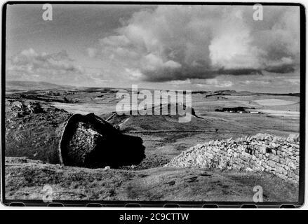 Hadrian Wall Northumberland England UK 1990 Hadrian's Wall (Latein: , Vallum Aelium), auch bekannt als die römische Mauer, Picts' Wall, Oder Vallum Hadriani in Latein, ist eine ehemalige defensive Befestigung der römischen Provinz Britannia, begonnen in AD 122 in der Regierungszeit des Kaisers Hadrian.[3] Es lief von den Ufern des Flusses Tyne in der Nähe der Nordsee zum Solway Firth auf der Irischen See, Und war die nördliche Grenze des Römischen Reiches, unmittelbar nördlich davon waren die Länder der nördlichen Alten Briten, einschließlich der Picts. Es hatte einen Steinsockel und eine Steinmauer. Es gab Milecastles mit zwei Stockfoto