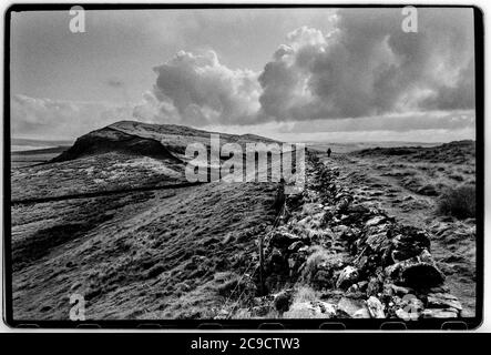 Hadrian Wall Northumberland England UK 1990 Hadrian's Wall (Latein: , Vallum Aelium), auch bekannt als die römische Mauer, Picts' Wall, Oder Vallum Hadriani in Latein, ist eine ehemalige defensive Befestigung der römischen Provinz Britannia, begonnen in AD 122 in der Regierungszeit des Kaisers Hadrian.[3] Es lief von den Ufern des Flusses Tyne in der Nähe der Nordsee zum Solway Firth auf der Irischen See, Und war die nördliche Grenze des Römischen Reiches, unmittelbar nördlich davon waren die Länder der nördlichen Alten Briten, einschließlich der Picts. Es hatte einen Steinsockel und eine Steinmauer. Es gab Milecastles mit zwei Stockfoto