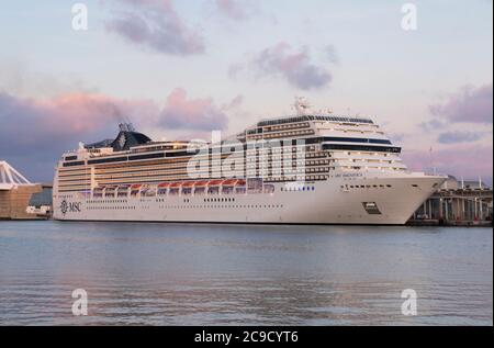 Das Kreuzfahrtschiff MSC Magnifica dockte bei Sonnenuntergang im Hafen von Barcelona an. Stockfoto