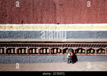 Ein Pilger dreht Gebetsräder im Sakya Kloster, Tibet Stockfoto