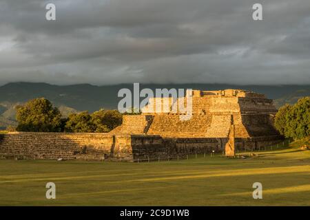 Stela 18 und die Pyramiden der Gruppe IV bei Sonnenaufgang in den präkolumbianischen Zapoteken-Ruinen von Monte Alban in Oaxaca, Mexiko. Ein UNESCO-Weltkulturerbe. Stockfoto