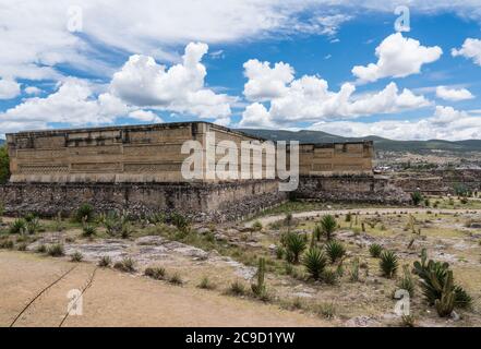 Kakteen und Agaven in den Ruinen der Zapoteken-Stadt Mitla in Oaxaca, Mexiko. Ein UNESCO-Weltkulturerbe. Der Palast, Gebäude 7, befindet sich im hinteren Teil Stockfoto