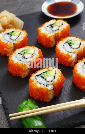 Hausgemachte california Brötchen, verrückt nach Krabbenstäbchen, Avocado, Gurke innen. Tobiko (fliegende Fischrogen) draußen. Stockfoto