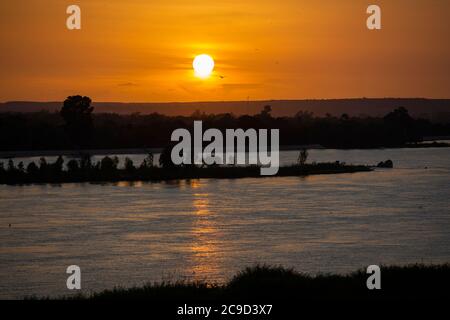 Der Fluss Niger fließt bei Sonnenuntergang durch die Hauptstadt Niamey, Niger, Westafrika. Stockfoto