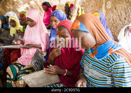 Halima Nayussa (17, C) besucht einen funktionellen Alphabetisierungskurs in der Tahoua Region, Niger. Im Rahmen des Alliance-Projekts 12/12 lernen Frauen, die noch nie eine Ausbildung erhalten haben, grundlegende mathematische und lesende Fähigkeiten, die ihnen unter anderem helfen werden, die Landwirtschaft als Unternehmen besser zu betreiben. Alliance 12/12 Projekt - Niger, Westafrika. September 18, 2018. Foto von Jake Lyell für Lutheran World Relief. Stockfoto