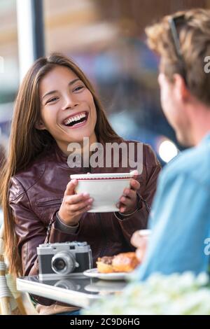 Glückliche Frau, die Kaffee im Café trinkt. Asiatische Mädchen, Gespräch mit Mann Freund lachen sitzen am Restauranttisch mit Spaß. Stadtpaar Stockfoto