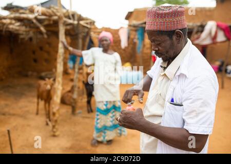 Ein Haus-zu-Tür-Dorf Tierarzt behandelt Tiere in der Heimat einer Frau Kleinbauern in Tahoua Region, Niger, Westafrika. Stockfoto