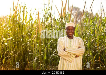 Ein Hirsezüchter steht auf seinem Bauernhof in der Tahoua Region, Niger, Westafrika, auf seinen Feldern. Stockfoto