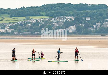 Arnside, Cumbria, Großbritannien. Juli 2020. Mit Grange over Sands im Hintergrund, Paddelboarding-Unterricht in Arnside, Cumbria an einem Tag, der mit Regen begann und bei feuchtem 21 Grad Celsius endete und sich am Freitag auf erwartete 29 Grad aufwärmte. Kredit: John Eveson/Alamy Live Nachrichten Stockfoto