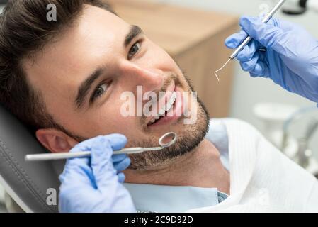 Mann, der Zähne Zahnärzte untersucht. Übersicht von Karies Vorbeugung Stockfoto