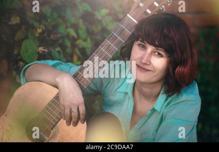 Nahaufnahme Porträt eines niedlichen Mädchen mit klassischer Gitarre. Gitarristen, Diversity-Konzept. Stockfoto