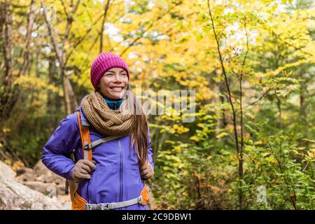 Glückliche asiatische Frau Wandern im Herbst Wald Natur Wandern auf Wanderweg. Hiker Mädchen mit Rucksack, Hut, Schal und Jacke auf Herbst Abenteuer reisen Stockfoto