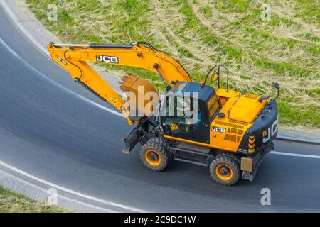 Bagger gelb JCB JS160W Fahren Sie auf der Straße zum Abbiegen. Russland, Sankt Petersburg. 16. juni 2020 Stockfoto