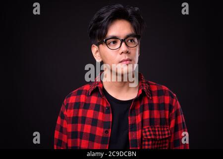 Junge schöne asiatische Hipster Mann mit Brille Stockfoto