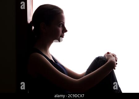 Junge Frau mit Trauer ließ seine Arme - Silhouette Stockfoto