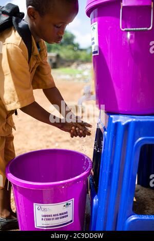 Ein Kind wäscht sich die Hände an einer Händewaschstation seiner Schule in Conakry, Guinea, Westafrika. Stockfoto