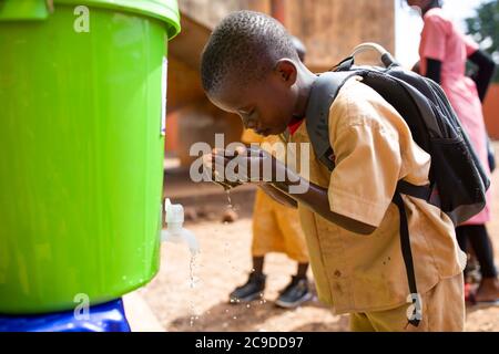 Ein Kind wäscht sich die Hände an einer Handwaschstation seiner Schule in Conakry, Guinea, Westafrika. Stockfoto