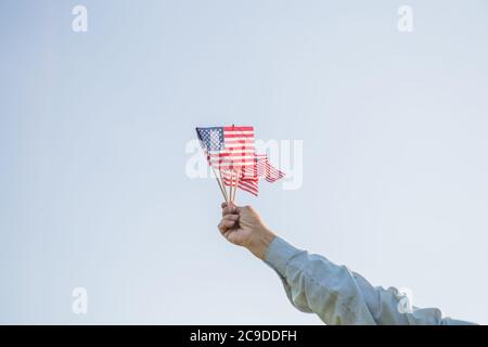 Patriotischer Senior feiert den unabhängigkeitstag der usa am 4. Juli mit einer Nationalflagge in den Händen. Tag der Verfassung und der Staatsbürgerschaft. National Gran Stockfoto