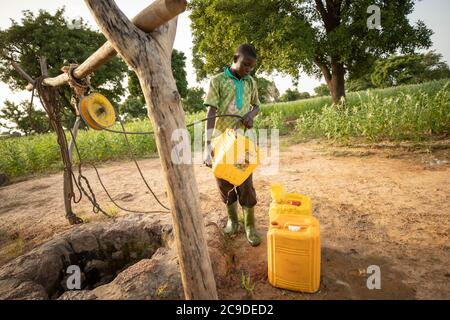 Ein Junge bezieht Wasser aus einem Brunnen in der Provinz Mouhoun, Burkina Faso, Westafrika. Stockfoto