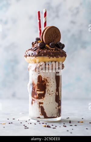 Schokoladenverwöhnendes Frosting exreme Milchshake mit Donut und Süßigkeiten. Crazy Freakshake Food Trend. Speicherplatz kopieren Stockfoto