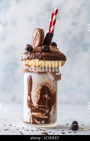 Schokoladenverwöhnendes Frosting exreme Milchshake mit Donut und Süßigkeiten. Crazy Freakshake Food Trend. Speicherplatz kopieren Stockfoto