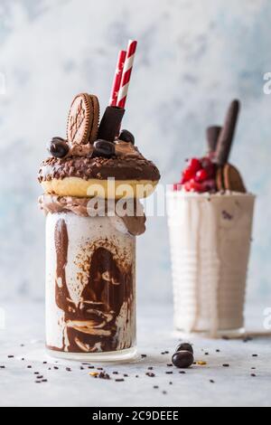 Schokoladenverwöhnendes Frosting exreme Milchshake mit Donut und Süßigkeiten. Crazy Freakshake Food Trend. Speicherplatz kopieren Stockfoto