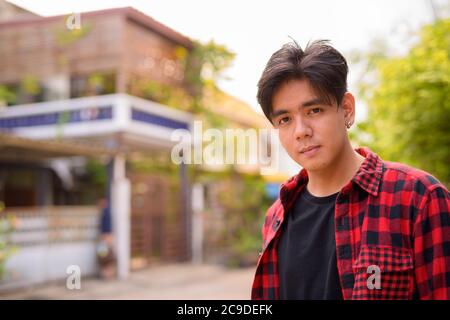 Junge gutaussehende asiatische Hipster Mann in den Straßen im Freien Stockfoto