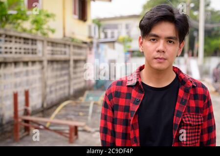 Junge gutaussehende asiatische Hipster Mann in den Straßen im Freien Stockfoto