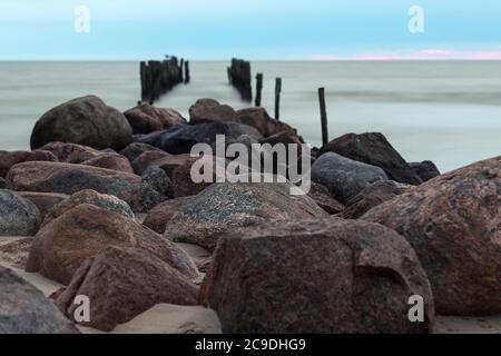 Reste eines alten Pier, alte Wellenbrecher am Strand, Lapmezciems, Lettland Stockfoto