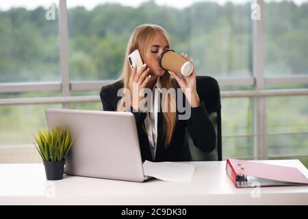 Blonde chattet am Telefon Kaffee trinken Stockfoto