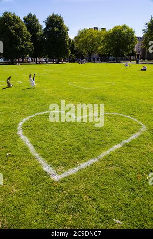 Lovehearts auf das Gras gemalt, um einen sicheren 2 Meter Sicherheitsabstand bei College Green anzuzeigen, während der Covid 19 Pandemie. Bristol, England. Juli 2020 Stockfoto