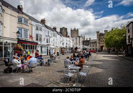 Am 28. Juli 2020 saßen die Leute draußen in Straßencafés auf dem Marktplatz von Wells, Somerset, Großbritannien Stockfoto