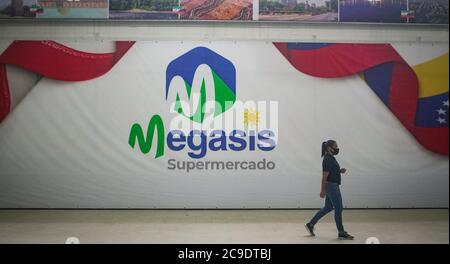 30. Juli 2020, Venezuela, Caracas: Eine Frau mit Mundschutz geht nach der Eröffnung im südamerikanischen Land in den iranischen Supermarkt 'Megasis'. Es ist der erste iranische Supermarkt in Venezuela, wo Mitte Juni ein Schiff mit iranischem Essen eingetroffen war. Aufgrund des Mangels an Devisen kann Venezuela kaum Lebensmittel, Medikamente und alltägliche Notwendigkeiten importieren. Die Importe werden durch die US-Sanktionen gegen die Regierung von Präsident Maduro erschwert. "Der Iran, wie auch jedes Land der Welt, hat ein Recht auf Freihandel", sagte der iranische Botschafter in Caracas, Soltani, bei der Eröffnung. Teheran h Stockfoto