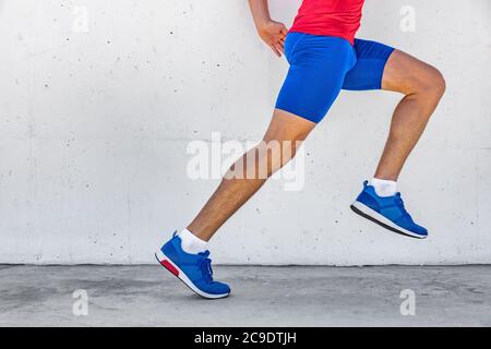 Fitness-Sportler Mann läuft auf Asphalt Bürgersteig in der Stadt Straße. Sportlicher Lifestyle. Nahaufnahme der Beine des Unterkörperläufers beim Workout-Marathonlauf gegen Stockfoto