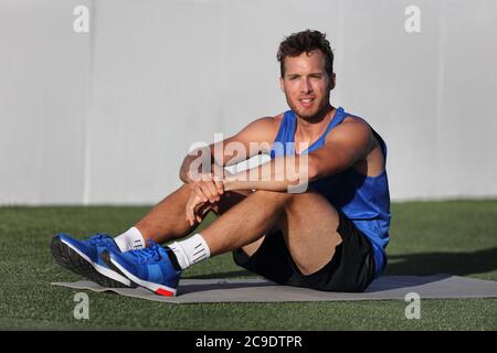 Gym Fitness Mann Portrait Entspannung auf Übungsmatte im Outdoor-Park. Glücklich fit männlichen Athleten gesund aktiven Lebensstil bereit für den Morgen Yoga-Praxis bei Stockfoto