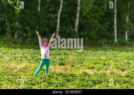 Kleines Mädchen posiert in Erdbeerfeld in Sevenoaks, Kent Stockfoto