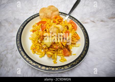 Bhel puri Bohnenkraut Snack Chaat Artikel aus Indien. Beliebte Straße Seite Lebensmittel Gericht serviert in Teller Löffel. Aus Puffreis, Tamaringsauce Stockfoto