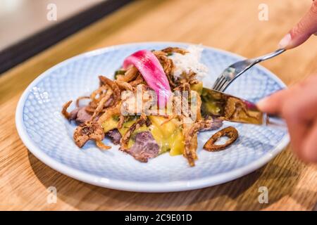 Dänisches Essen war ein Smorrebrod Open Sandwich Frau, die im Restaurant gegessen hat. Person mit Gabel und Messer schneiden Rindfleisch Mittagessen Mahlzeit aus Dänemark. Kopenhagen-Stadt Stockfoto