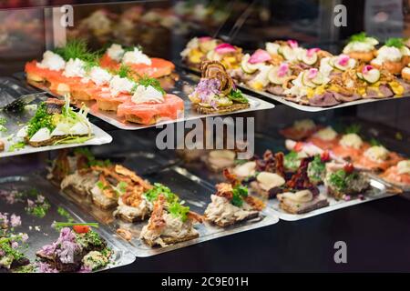 Dänisches Smorrebrod traditionelles offenes Sandwich im Lebensmittelmarkt Kopenhagen. Viele Sandwiches mit Meeresfrüchten und Fleisch, geräuchertem Lachs. Stockfoto