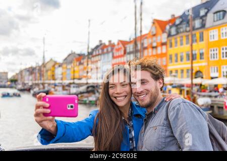 Kopenhagen Reise paar Touristen machen Selfie-Foto mit Handy-Kamera. Lächelnde junge Leute Studenten im alten Hafen Nyhavn, Tourismus dänischen Wahrzeichen in Stockfoto