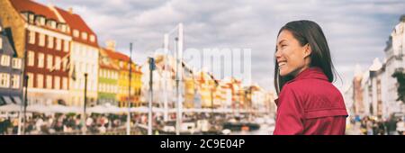 Glückliche asiatische Frau zu Fuß in Kopenhagen City Street. Dänemark Frühling Reise Touristen Besuch Nyhavn berühmte Attraktion, alten Wasserkanal Banner. Stockfoto