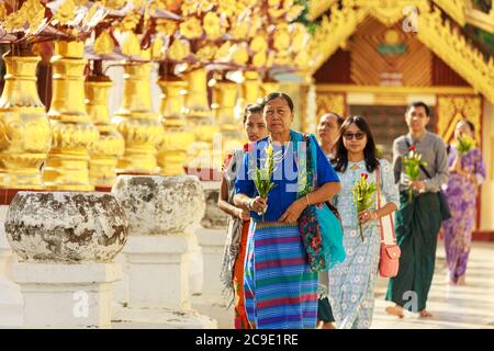 Bagan/Myanmar - 4. Oktober 2019: Eine Gruppe von Burmesen trägt Blumen, um Buddha-Bildern in einem Tempel Respekt zu erweisen. Stockfoto