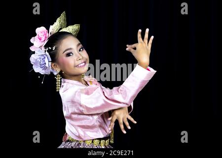 Ein isoliertes Bild mit schwarzem Hintergrund eines asiatischen Mädchens, das in traditionellen Kostümen im Norden Thailands gekleidet ist und traditionellen Tanz aufführt. Stockfoto