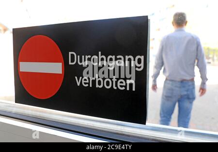 Rostock, Deutschland. Juli 2020. Steffen Stockmann-Schwenn, Hausmeister der CJD Jugenddorf-Christophorusschule Rostock, steht hinter einem Aufkleber an einer Tür mit der Aufschrift 'Urchgang verboten'. Mecklenburg-Vorpommern wird als erstes Bundesland am 3. August 2020 den landesweiten Regelbetrieb der Schulen wieder aufnehmen. Rund 150 Schüler werden nach den Sommerferien in ihren Schulen erwartet. Quelle: Bernd Wüstneck/dpa-Zentralbild/dpa/Alamy Live News Stockfoto